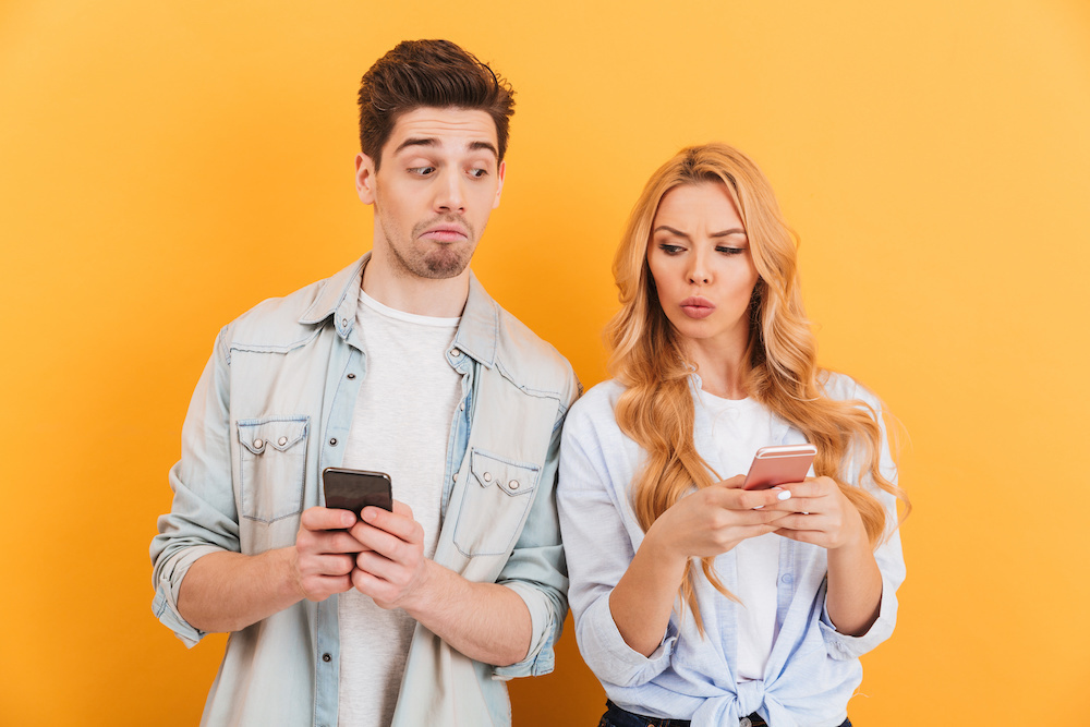 携帯を覗く男女 疑い 浮気