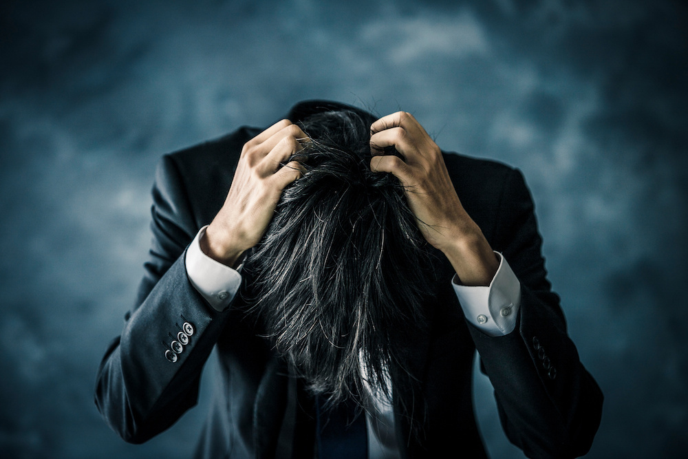 頭を抱えている男性の画像