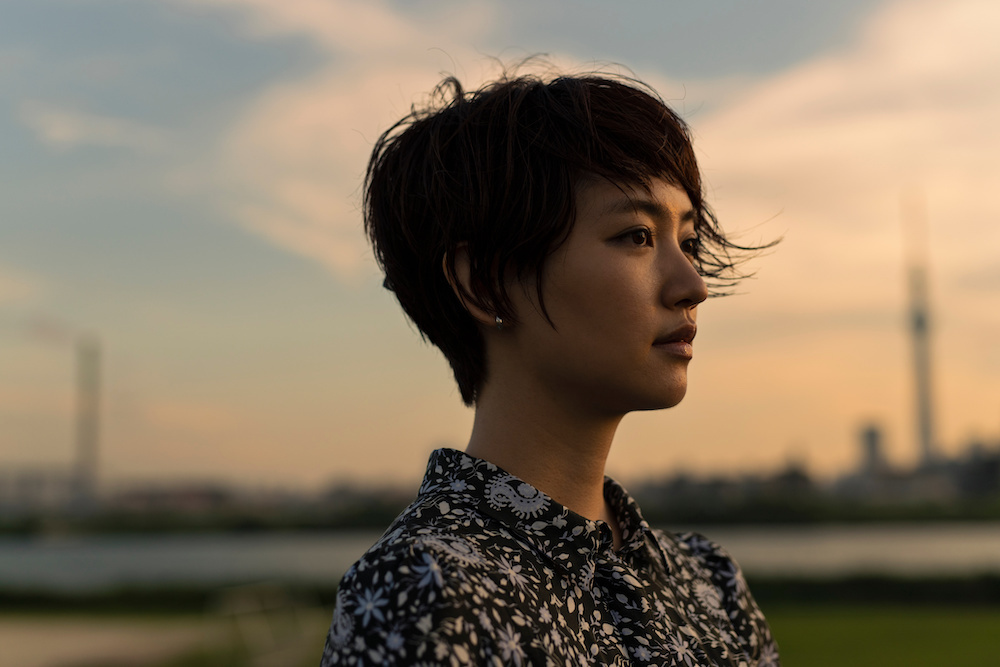 夕暮れ時に佇む女性の画像