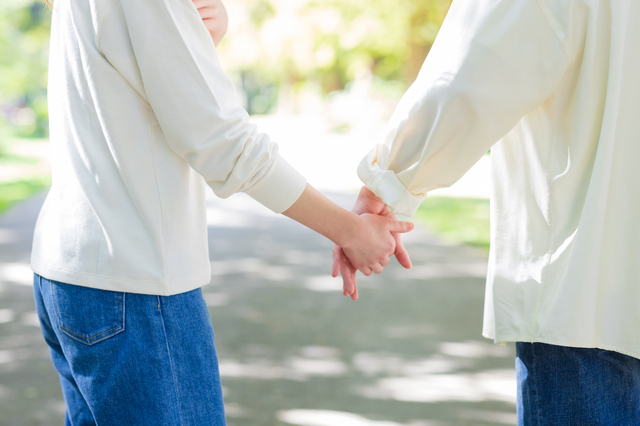 手を繋ぐカップルの画像