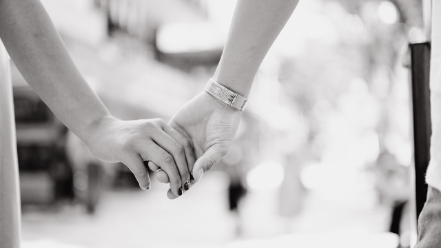 手を繋ぐカップルの画像