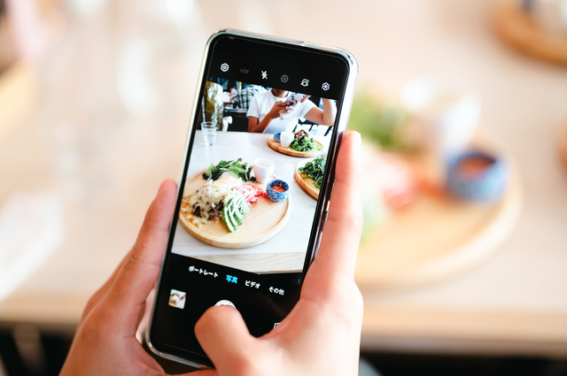 スマホで料理を撮影する手元の画像