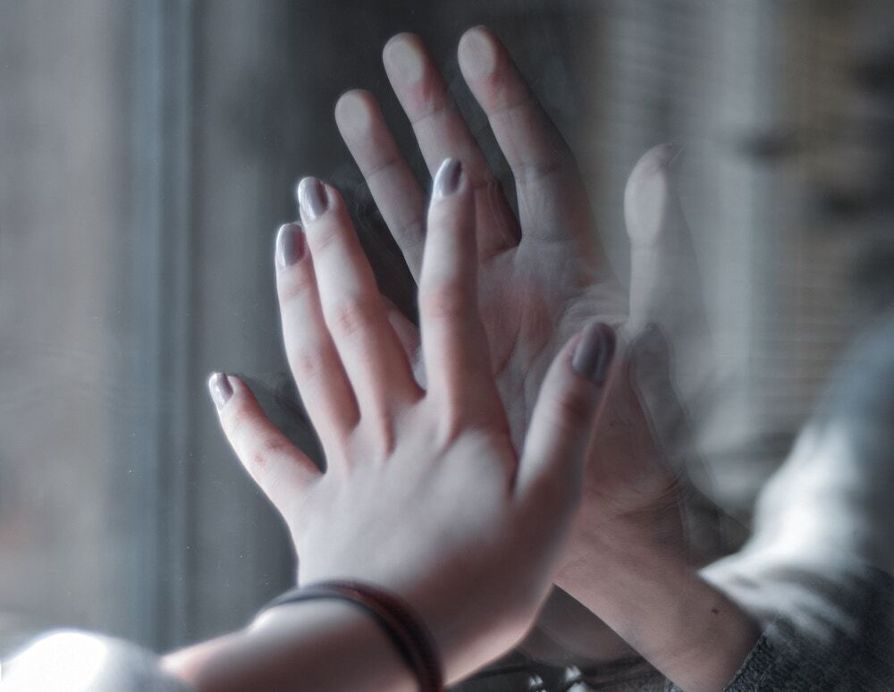 ガラス越しの男女の手