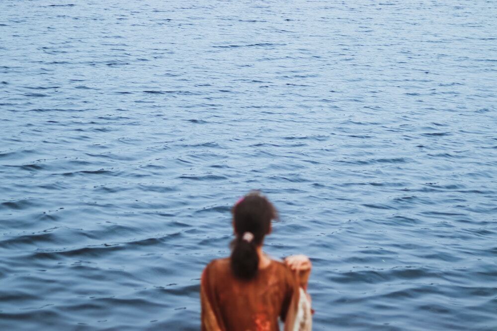 海を見ている女性の背中の画像