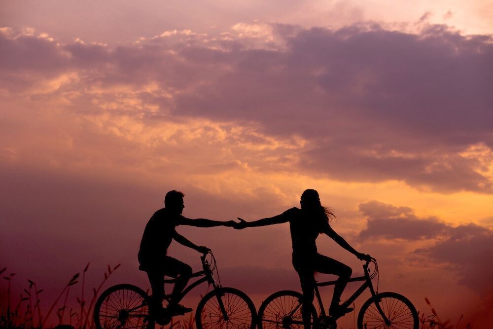 夕日の中自転車に乗っている二人の画像
